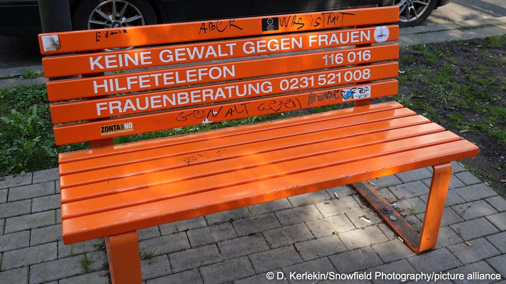An orange bench with contact numbers for gender based violence hotlines in Germany, in the German state of North Rhine Westphalia | Photo: D. Kerlekin / Snowfeld Photography / picture alliance