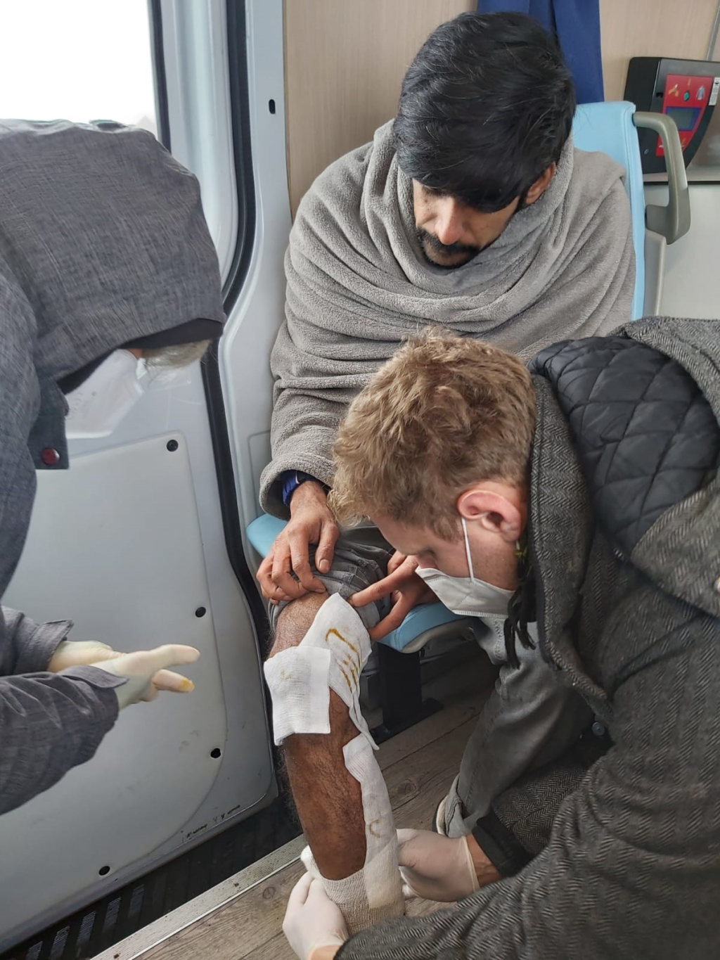 عضو في فريق ترابرت الطبي يضع ضمادة على ساق مهاجر في عيادة متنقلة لمنظمة "الفقر والصحة في ألمانيا"