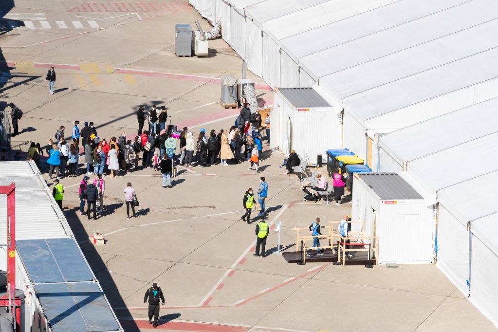 Dozens of people queue in front of a tent at the arrival center for refugees from Ukraine at the former Tegel Airport in Berlin, Germany every day | Photo: ARCHIVE/EPA/CHRISTOPH SOEDER