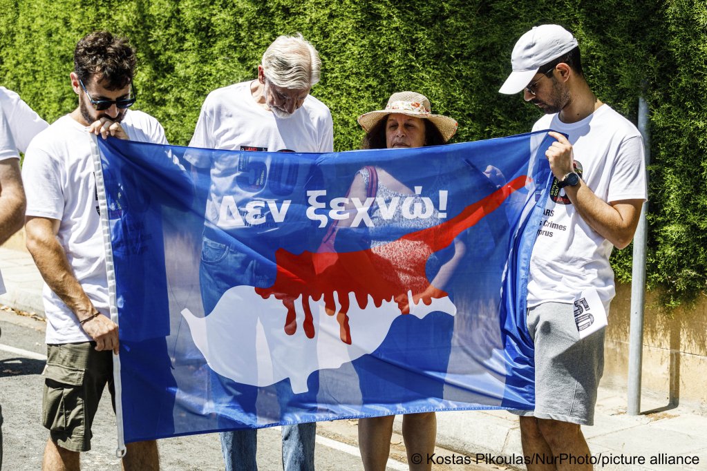 File photo: A group of Greek-Cypriots and Turkish-Cypriots hold a bloodied Cyprus flag reading 'I don’t forget,' while marking the 50th anniversary since the Turkish invasion | Photo: Kostas Pikoulas/NurPhoto/picture alliance