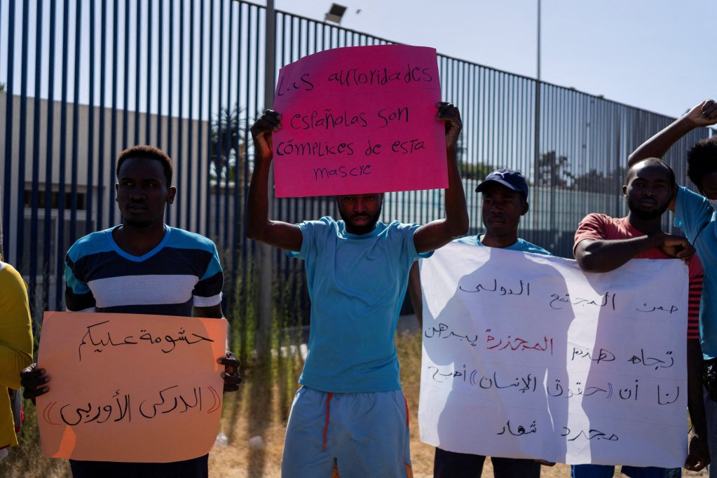 Un manifestant tient une pancarte indiquant "les autorités espagnoles se conforment à ce massacre" devant le centre de séjour de courte durée CETI de Melilla après qu'au moins 23 migrants sont morts en essayant d'atteindre l'enclave espagnole, à Melilla, Espagne, le 27 juin 2022.