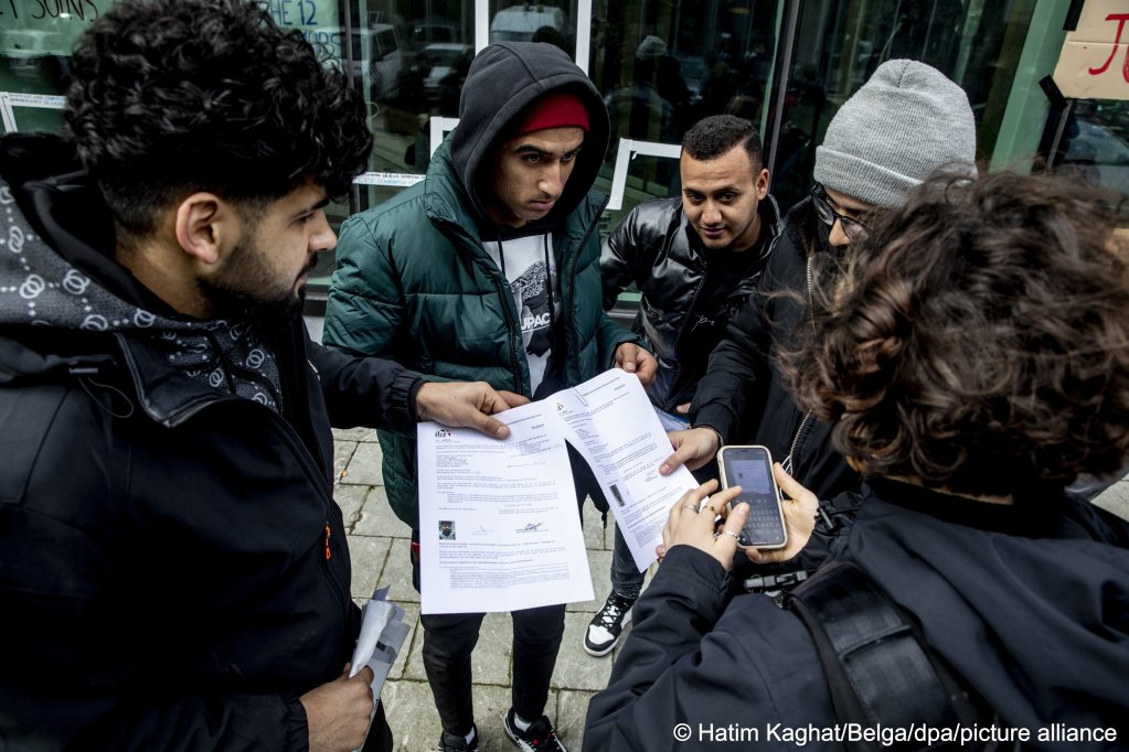 In this picture, the asylum seekers appear to be showing their official documents to reporters | Photo: Picture-alliance