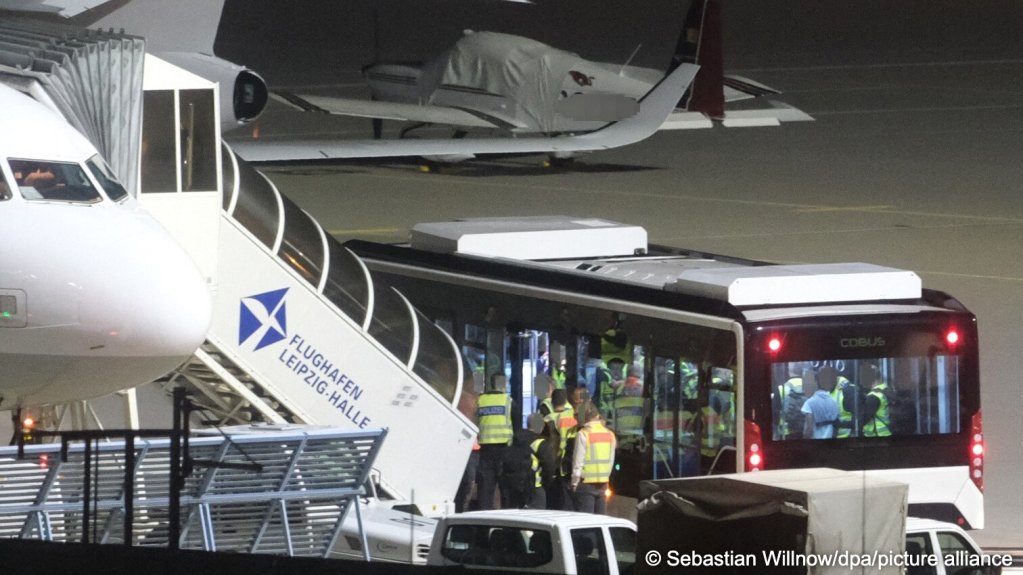 A bus carrying men accompanied by German federal police officers stands next to an aircraft at Leipzig/Halle Airport. Using a charter flight, the German federal police transported Afghan nationals who were required to leave the country back to their country of origin, August 25, 2026 | Photo: picture-alliance