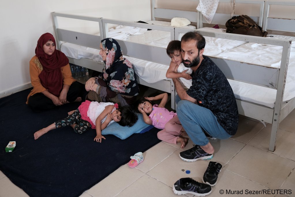 A migrant family from Afghanistan, intercepted by Turkish security forces after crosing illegaly into Turkey, awaits their fate at a migrant  procesing center in the eastern border city of Van on August 22, 2021 | REUTERS/MuradSezer