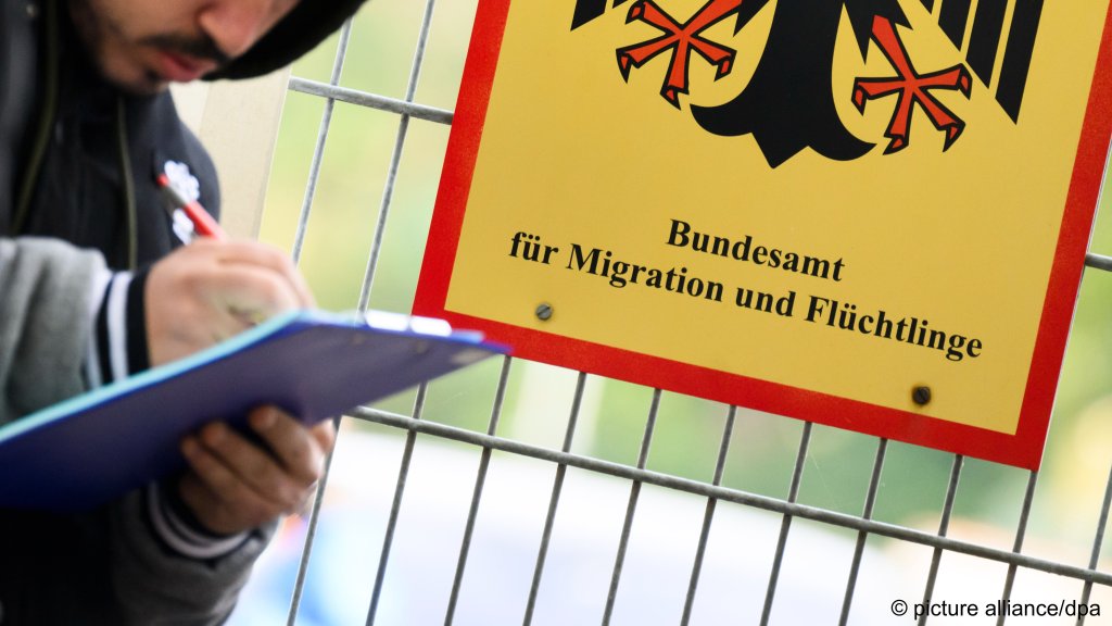 Asylum in Germany: A man filling out a form in front of a sign for the federal agency for migration and refugees (BAMF) on October 16, 2023 | Photo: picture alliance/dpa