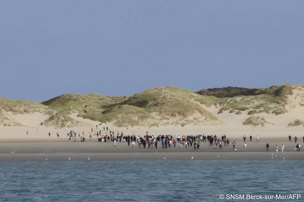 Migrants wait in the dunes behind the beach before heading down towards the shore when a boat draws near enough to board | Photo: Handout / SNMS Berck sur Mer / AFP