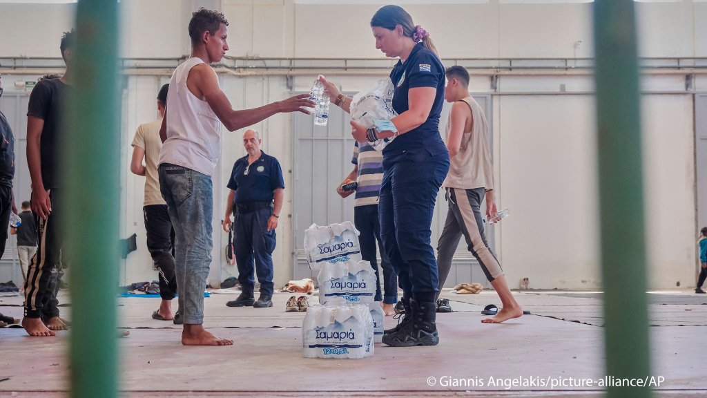 A Greek coast guard gives water to migrants from Africa as they take a shelter in Agia port, Chania, Crete island, Greece, Monday, July 7, 2025 | Photo: Giannis Angelakis / picture alliance / Associated Press