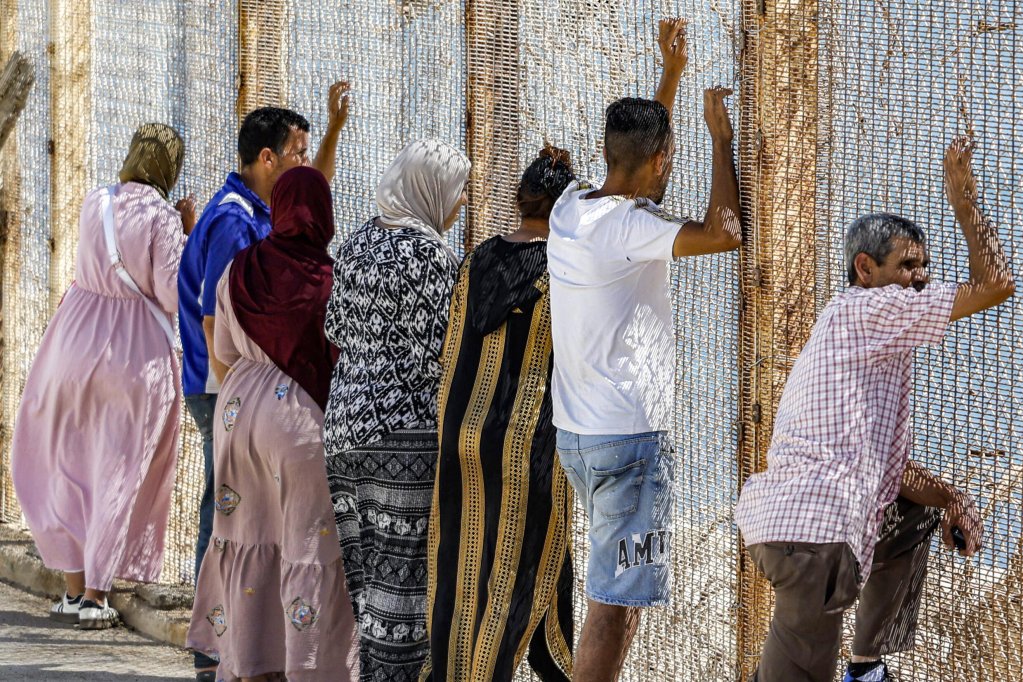 Families of missing migrants look across the border fence separating Morocco from Ceuta, at Bab Ceuta, near the village of Fnideq. August 2, 2026. | Photo: AFP