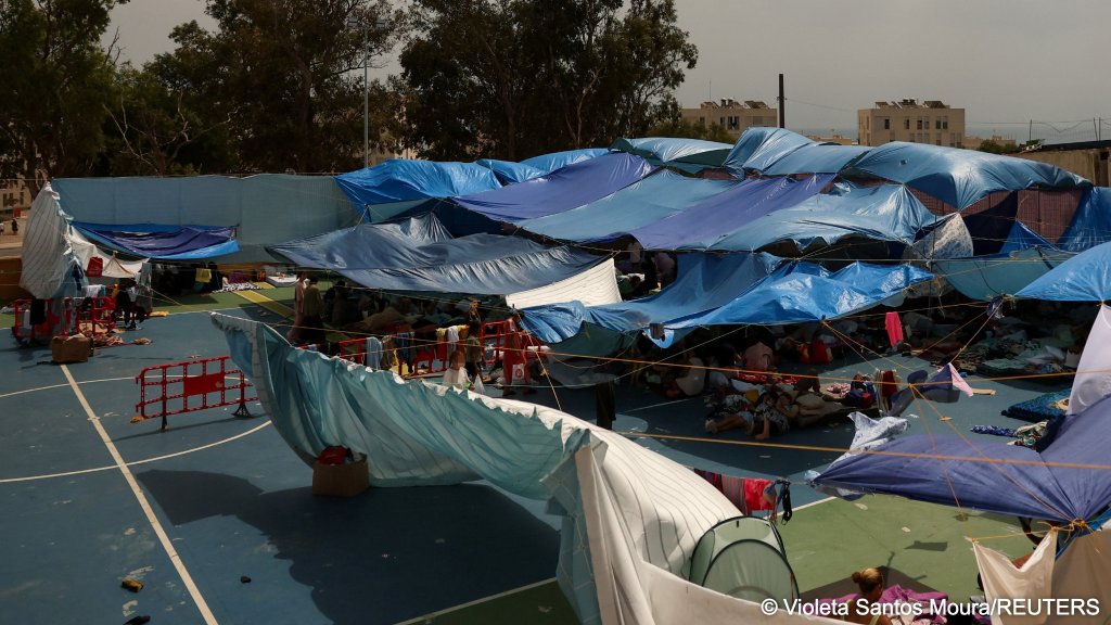 Migrant women and children take refuge under tarps and tents in a sports field set up by local residents as an improvised shelter for women and children | Photo: Violeta Santos Moura/REUTERS