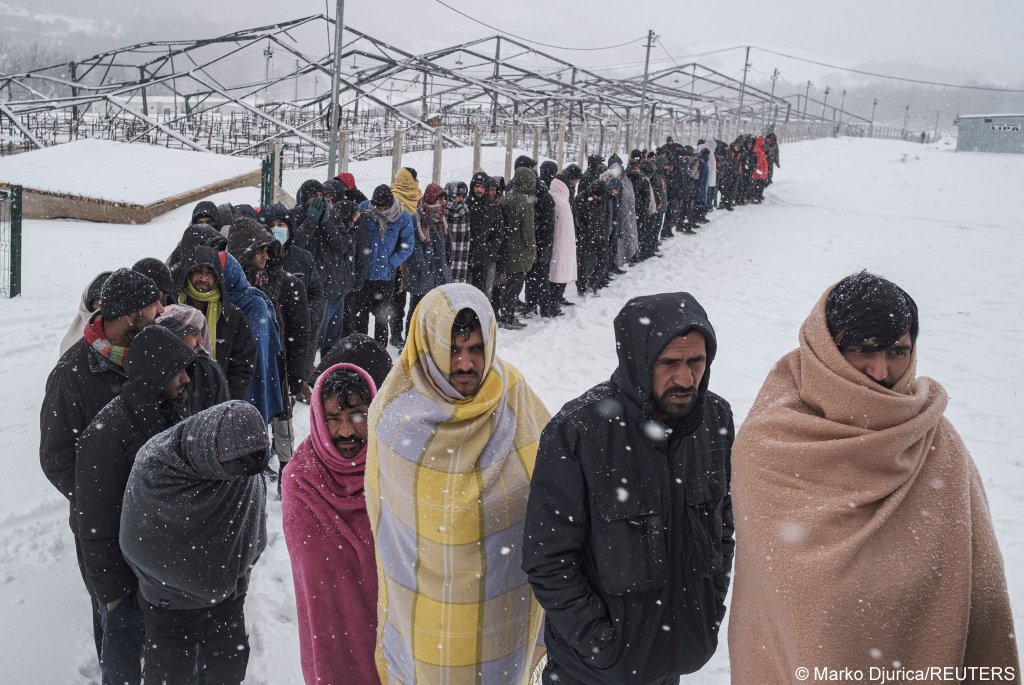 Migrants queue to receive food during a snowfall in the Lipa migrant camp in northwest Bosnia on January 11, 2021 | Photo: Marko Djurica/Reuters