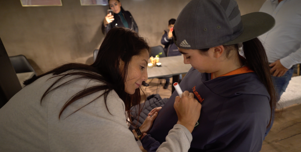Nadia Nadim signs a football jersey for a young girl, Helin Kanbul | Photo: Claudia Jardim