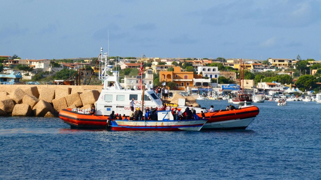 Tunisian migrants aboard a boat intercepted off Lampedusa enter the island's port | Photo: ANSA/Elio Desiderio