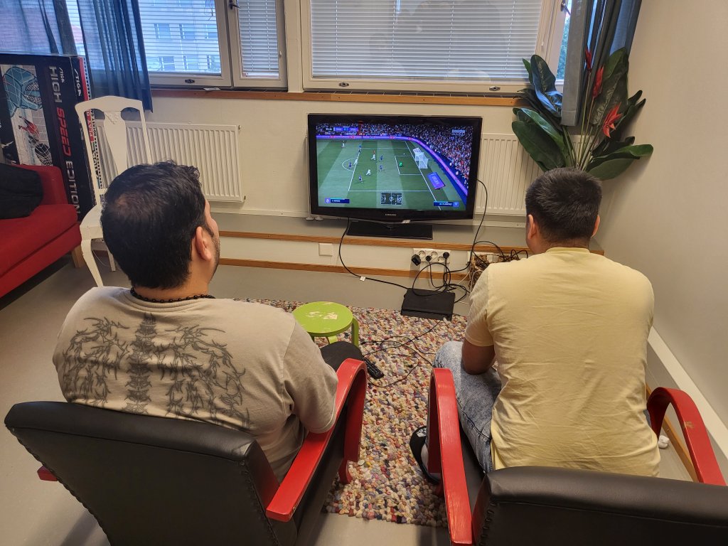 Customers playing soccer match simulator FIFA in the Living Room premises in Helsinki, Finland | Photo: Ben Bathke/InfoMigrants