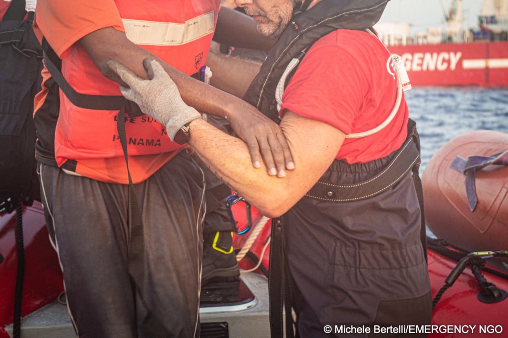 A Life Support crew member is helping a rescued migrant in the Central Mediterranean on August 17, 2026 | Photo: Michele Bertelli/EMERGENCY NGO