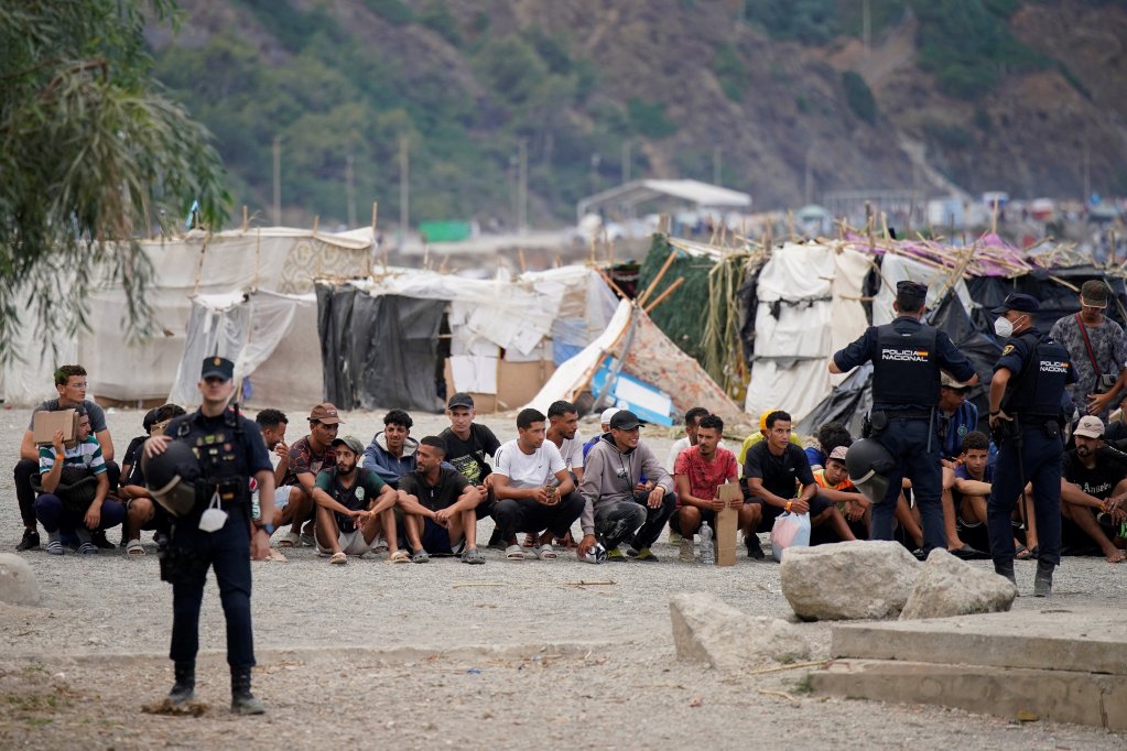 Migrants who crossed into Ceuta wait for food distribution from the Red Cross on Trampolin Beach, September 2026 | Photo: Reuters
