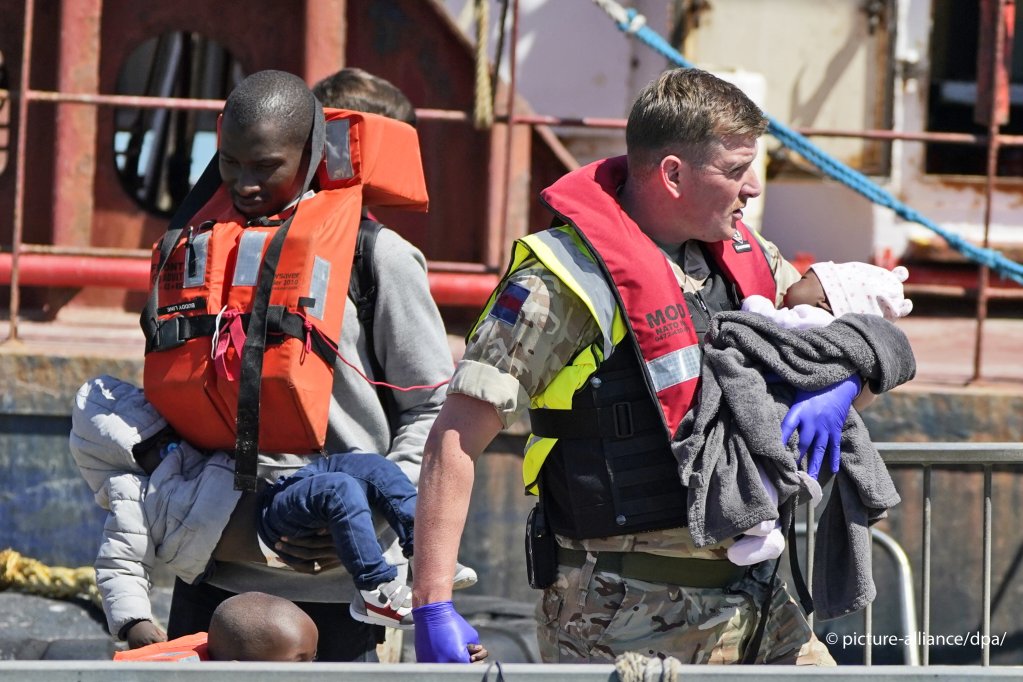 A British soldier helps bring small children ashore after they and their family crossed the Channel in a small boat | Photo: Stuart Brock / Anadolu Agency / picture alliance