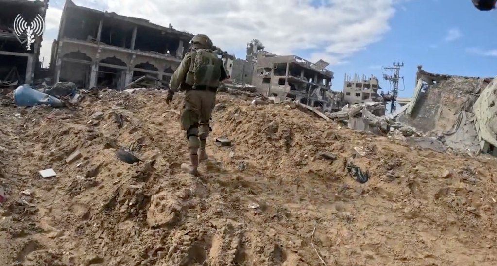 Un soldat israélien patrouille dans un quartier de Gaza, détruit par les bombardements israéliens, en novembre 2023. Crédit : Reuters