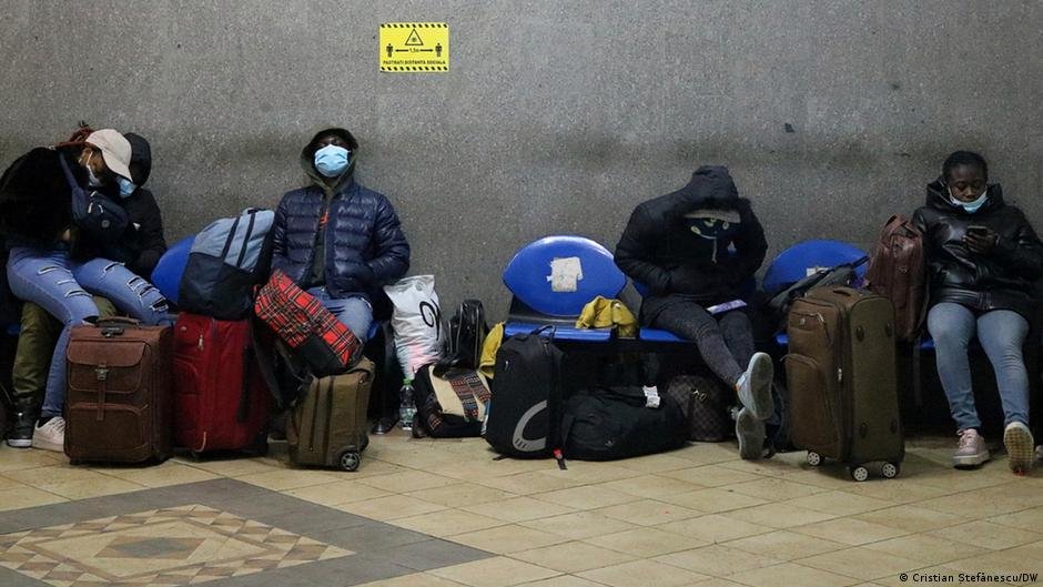 African students wait with their luggage in Romania. 