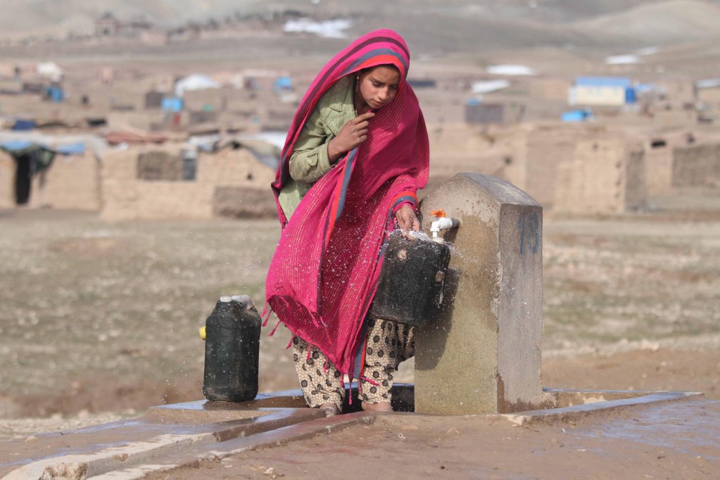 File photo: An internally displaced Afghan girl fills a water can at a community tap outside her temporary shelter on the outskirts of Herat, Afghanistan, 22 January 2020 | Photo: Jalil Rezayee / EPA