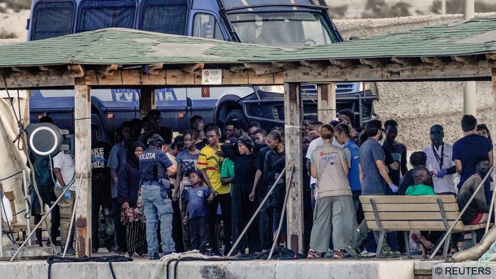 Migrant survivors stand on the dock after a double shipwreck left at least 26 people dead and many more reportedly missing | Photo: Chiara Negrello / Reuters