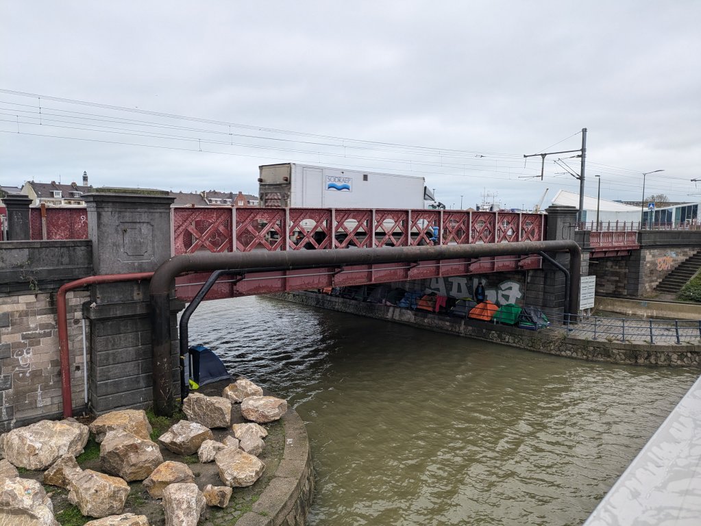 Migrants camping by the canal in Calais city center. Large boulders prevent migrants from camping on the grass | Photo: InfoMigrants