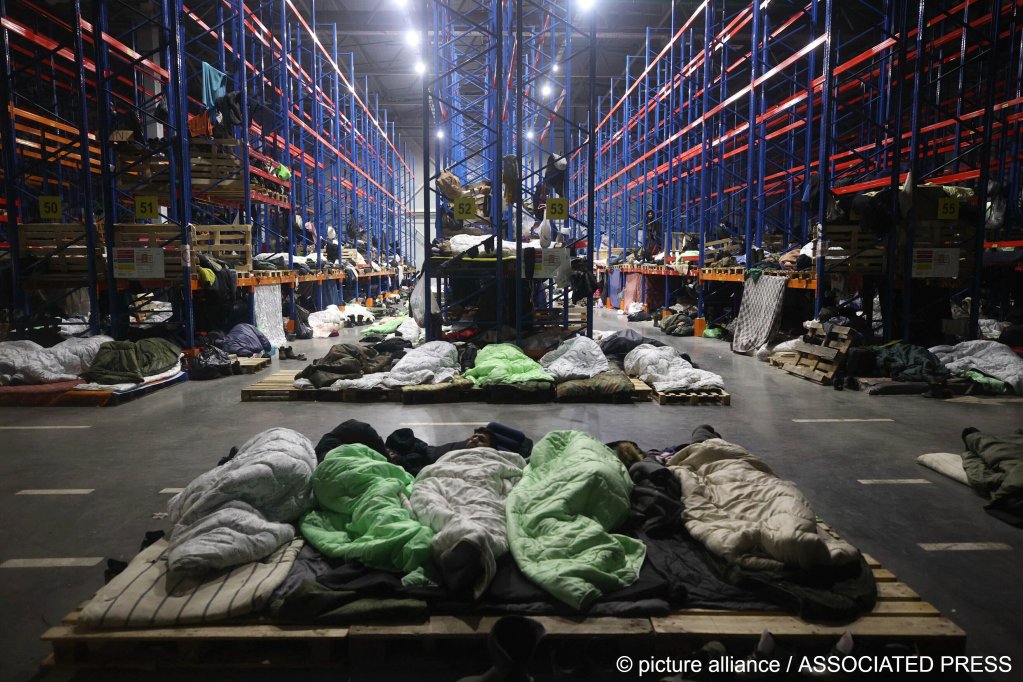 From file: Migrants sleep a logistics center at the checkpoint 'Kuznitsa' at the Belarus-Poland border near Grodno, Belarus on November 22, 2021| Photo: Maxim Guchek/BelTA/AP
