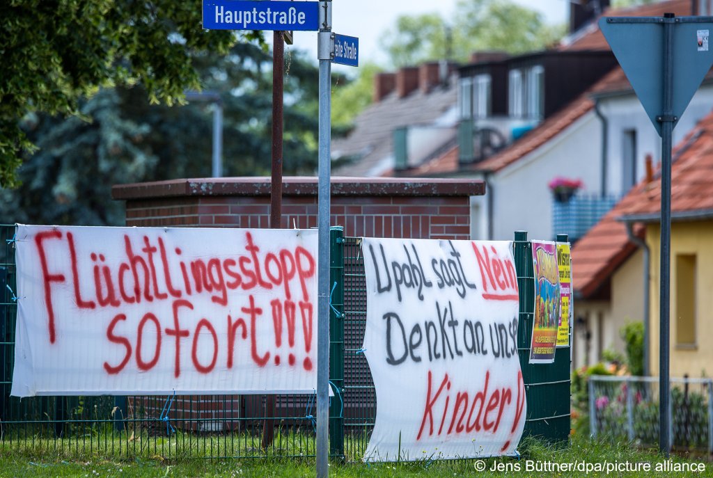 Protest banners against a planned migrants shelter hang on the street in the center of Upahl | Photo: Jens Büttner/dpa/picture-alliance