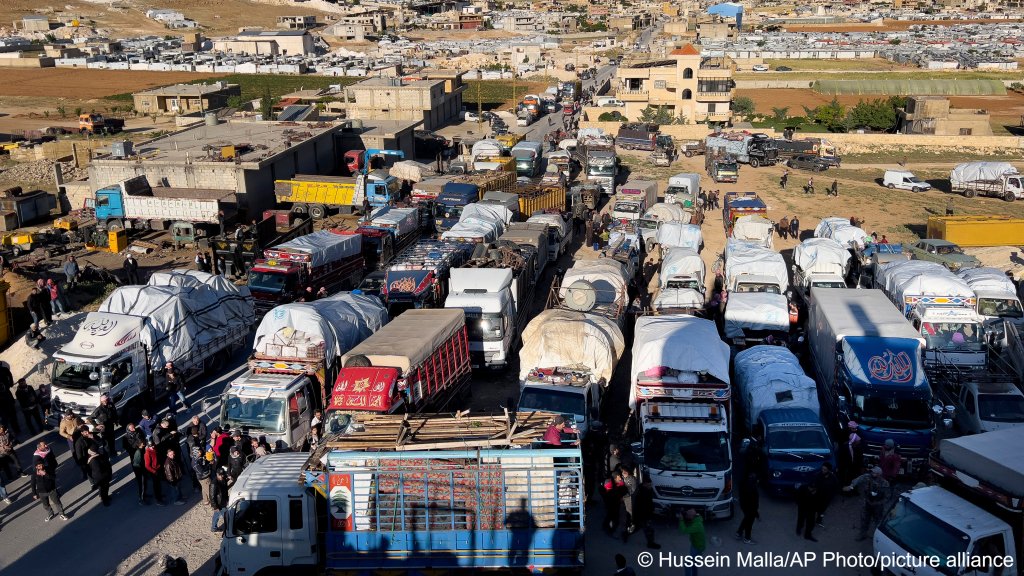 Dozens of trucks were waiting to depart from Arsal in northeastern Lebanon to Syria on May 14, 2024. Some of the returning refugees said they were hopeful, while others expressed worry about their own or their loves ones' safety | Photo: Hussein Malla/AP Photo/ picture alliance