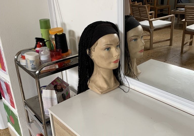 Deborah explains how some women learn to do braids at the WGSS and then go on to set up their own businesses braiding other women's hair in Sicily | Photo: Emma Wallis / InfoMigrants