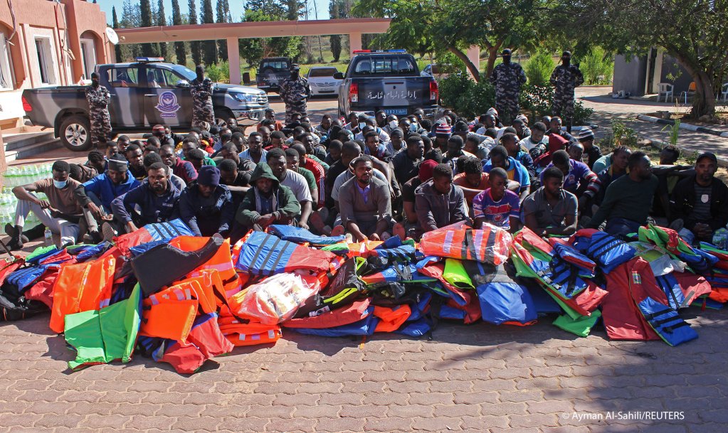 Migrants sit at a security checkpoint after they were intercepted by Libya's Interior Ministry before attempting a journey to Europe, in the city of Khoms | Photo: REUTERS/Ayman Al-Sahili 