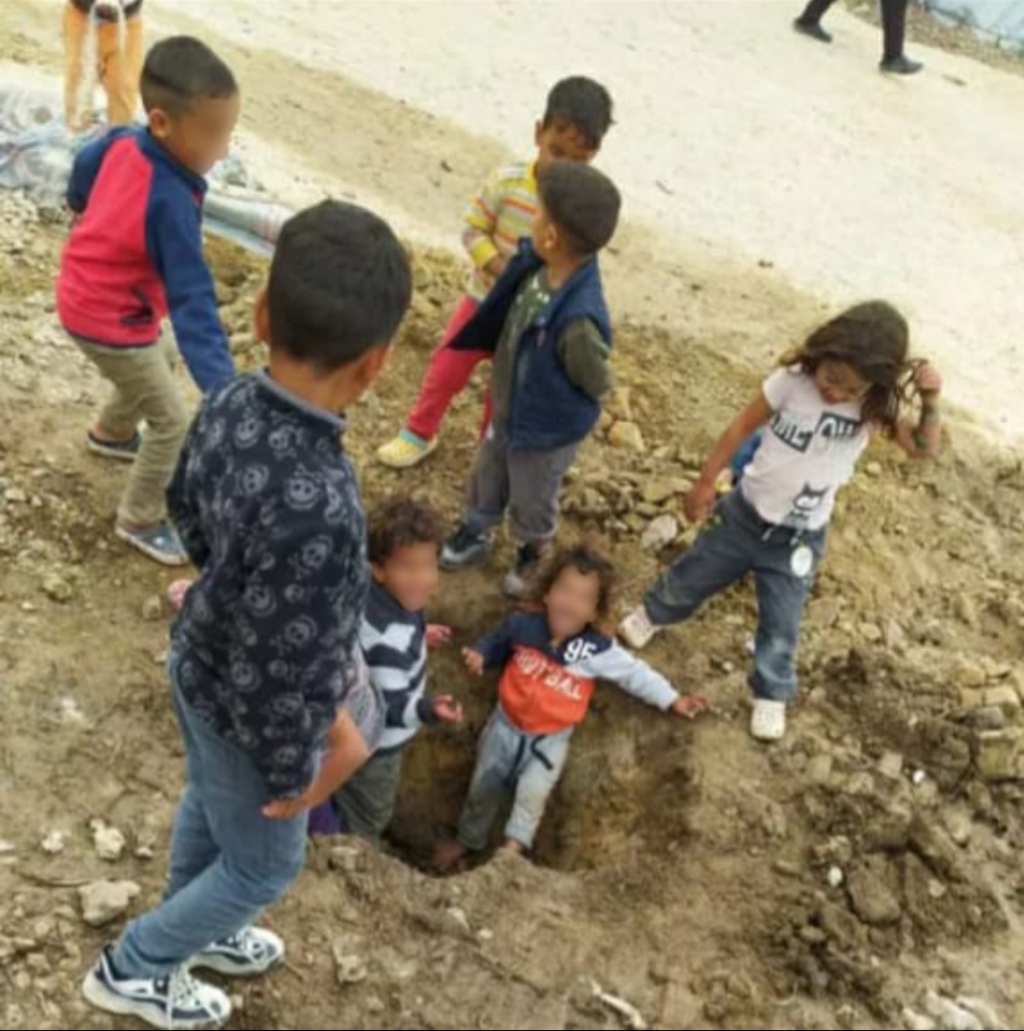 صورة من تقرير هيومن رايتس ووتش تظهر أطفالاً يلعبون في التربة في مخيم مافروفوني | المصدر: هيومن رايتس ووتش / خاص