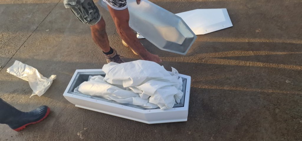 The body of the five-month-old infant rests in a tiny white coffin on the quayside at Lampedusa | Photo: Private