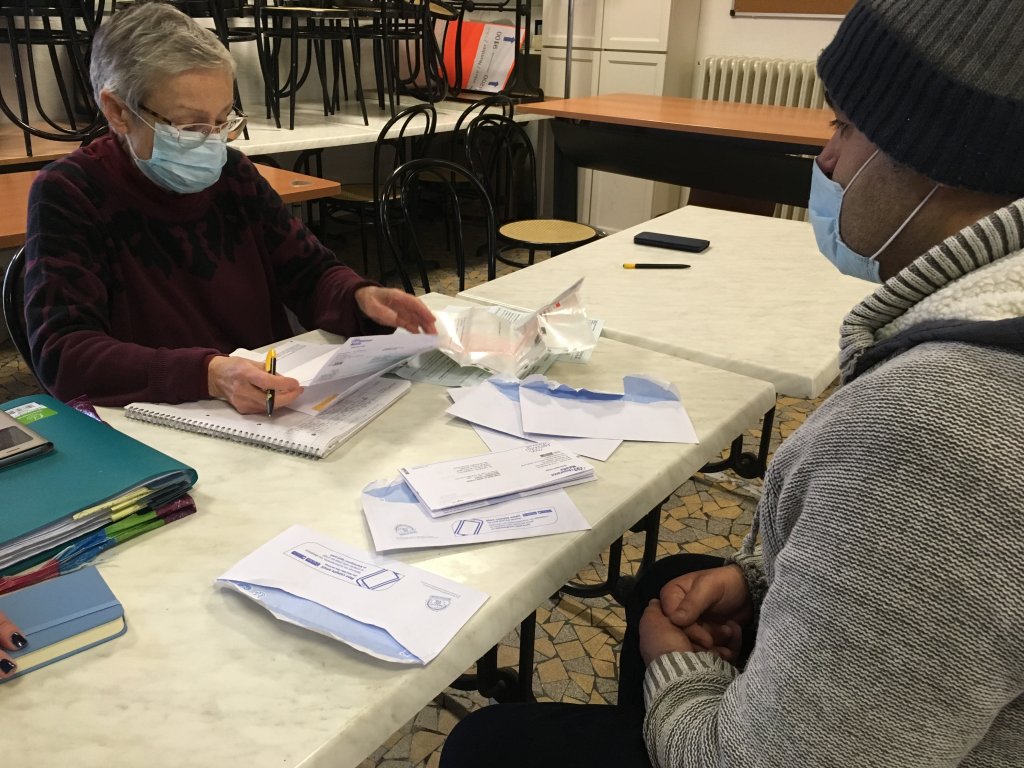 Dominique, bénévole, aide Tarakeh, un demandeur d'asile afghan à déchiffrer son courrier, le 15 janvier 2021. Crédit : InfoMigrants