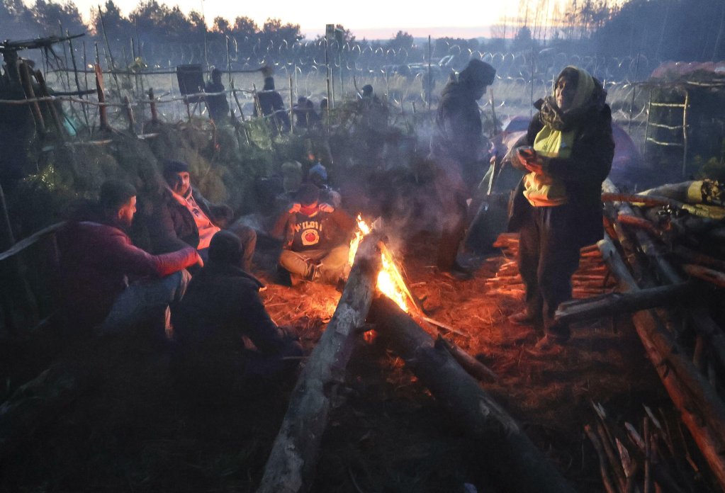 File photo: Migrants from the Middle East and elsewhere warm up by a fire at the Belarus-Poland border near Grodno, Belarus,10 November 2021 | Photo: AP - Ramil Nasibulin 
