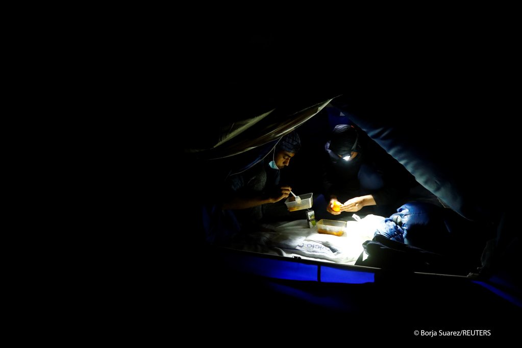Migrants having dinner at a makeshift camp on Gran Canaria on March 7, 2021 | Photo: Borja Suarez/Reuters