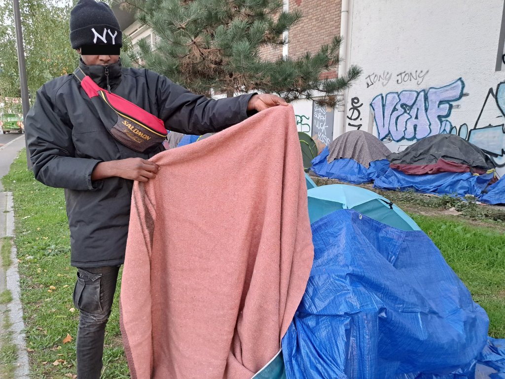 Mana montre sa couverture humide, le 24 octobre sur le campement d'Ivry-sur-Seine. Crédit : InfoMigrants