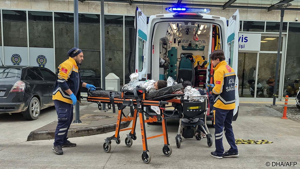 Some of the Afghan migrants injured after their boat capsized off Turkey are brought to medical attention on land | Photo: DHA / AFP