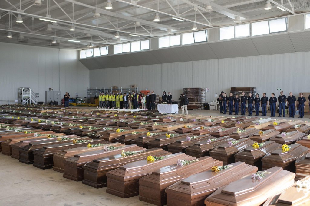 ANSA / وفود الاتحاد الأوروبي في مطار لامبيدوزا أمام صفوف أكفان ضحايا حادث تحطم سفينة، أودى بحياة أكثر من 300 مهاجر، في تشرين الأول / أكتوبر 2013. المصدر: إي بي إيه/ روبرتو سالوموني. صورة من الأرشيف.
