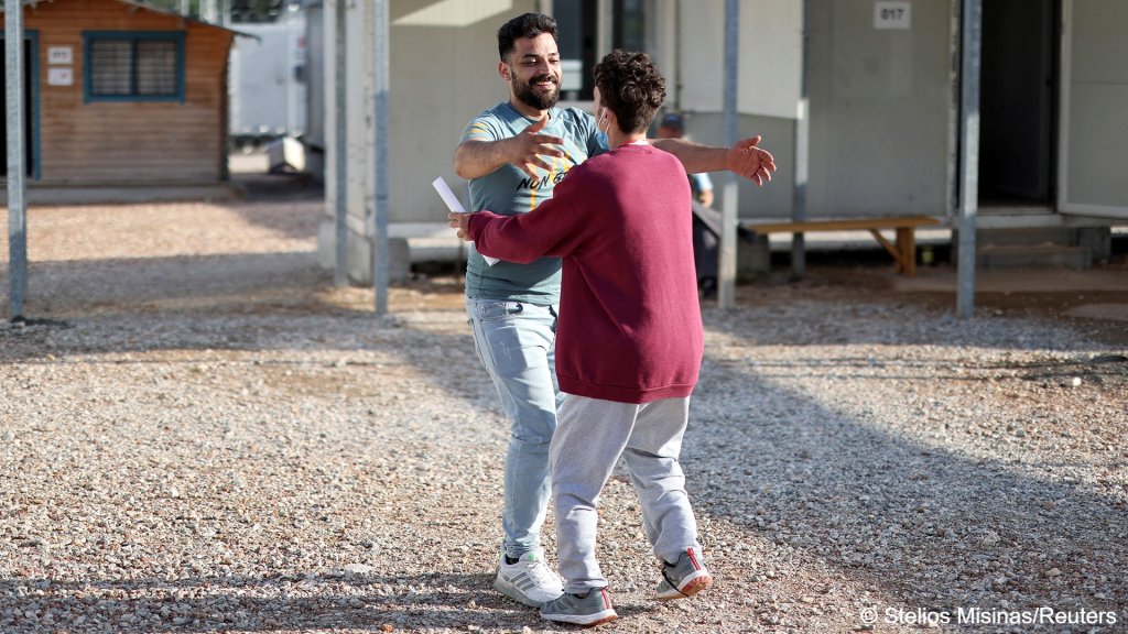 A survivor who was rescued reunites with his brother at Malakasa camp | Photo: Reuters/Stelios Misinas