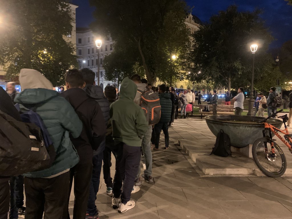 Hundreds of migrants arrive every night to wait in line for food in Trieste's town square, not far from the central station | Photo: Emma Wallis / InfoMigrants