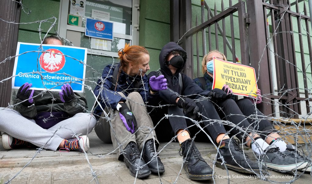 Protesters chained themselves to the fence surrounding the headquarters of Poland's Border Guards and put barbed wire on top of the fence to protest the government's refusal to let in a group of migrants, in Warsaw, Poland, Monday, Aug. 23, 2021 | Photo: AP Photo/Czarek Sokolowski