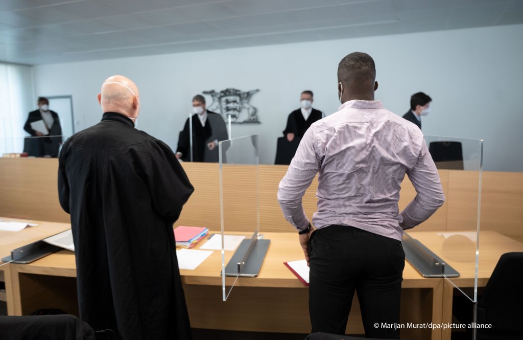 An asylum seeker from Cameroon and his lawyer (left) stand in a hall inside the administrative court Stuttgart in the German state of Baden-Wuerttemberg | Photo: Marijan Mura/picture-alliance/dpa