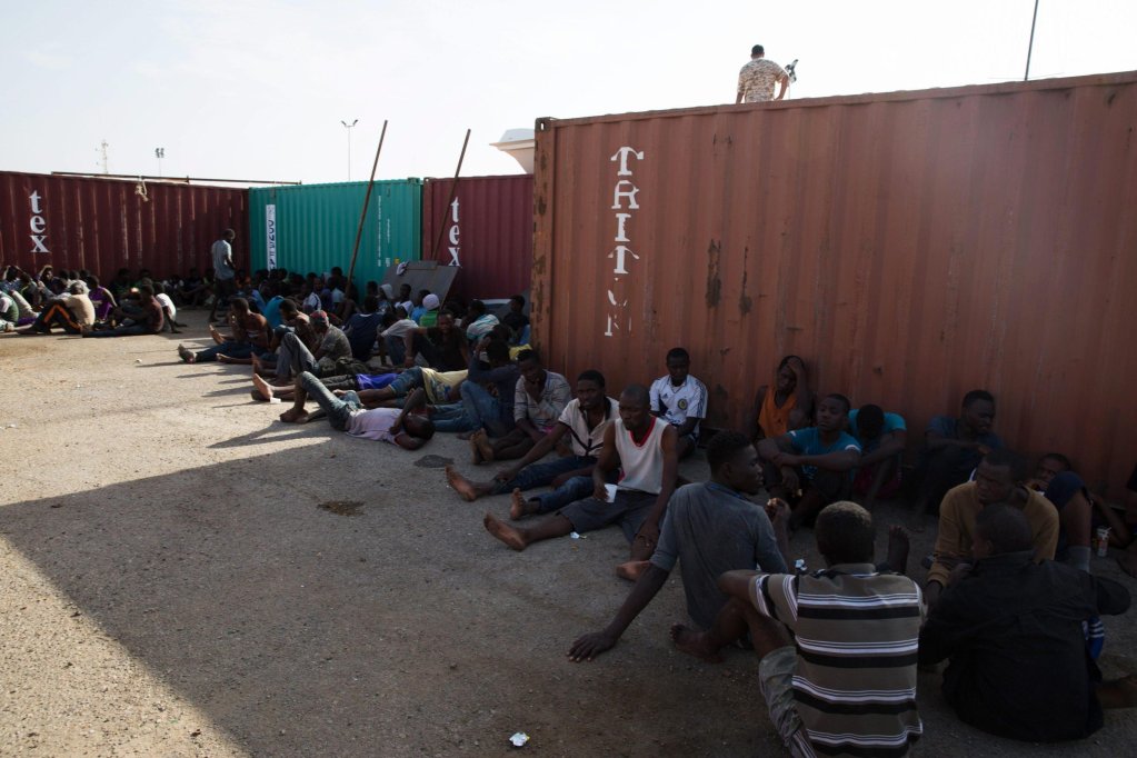 Migrants who were rescued off the coast of Libya rest at the Port of Tripoli before being transported to a detention center in Tripoli, Libya | PHOTO: EPA/STRINGER