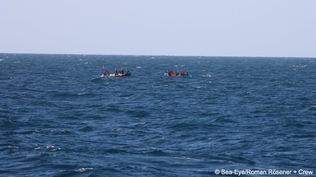 The rescue team approaches the overcrowded wooden boat at sea | Photo: Roman Rösener and Crew Sea-Eye press office