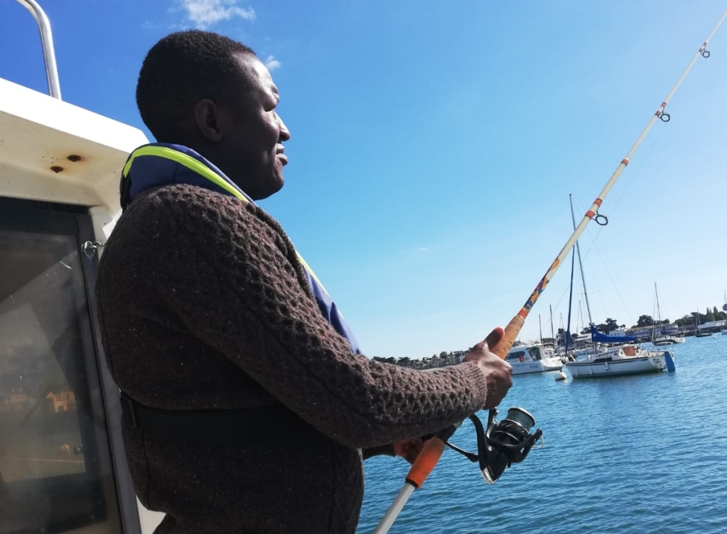 Abdulahman s'essaie à la pêche à l'arrière du bateau. Crédit : Le Temps partagé