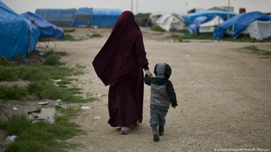 From file: A Syrian woman holds her child as they walk through a refugee camp in northern Syria | Photo: Picture-alliance/AP Photo/M.Alleruzzo