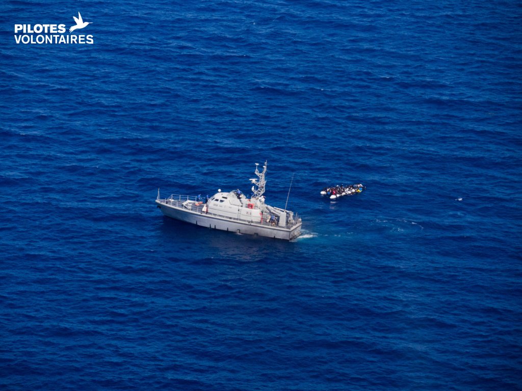 صورة لمركبة تابعة لخفر السواحل  بالقرب من قارب للمهاجرين/ رويترز