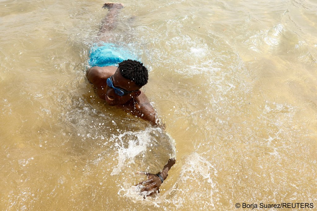 Many migrants who arrive by boat can't actually swim, so learning to swim in the shallows helps build confidence | Photo: Borja Suarez/Reuters