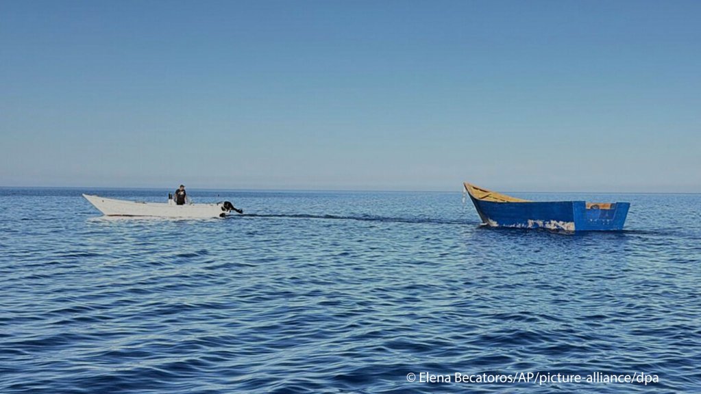 A boat used by migrants to cross the Mediterranean Sea is towed from Tripiti beach to the Karave the port of Gavdos, Greece, on Monday, July 7, 2025 | Photo: Elena Becatoros / AP / picture alliance / dpa
