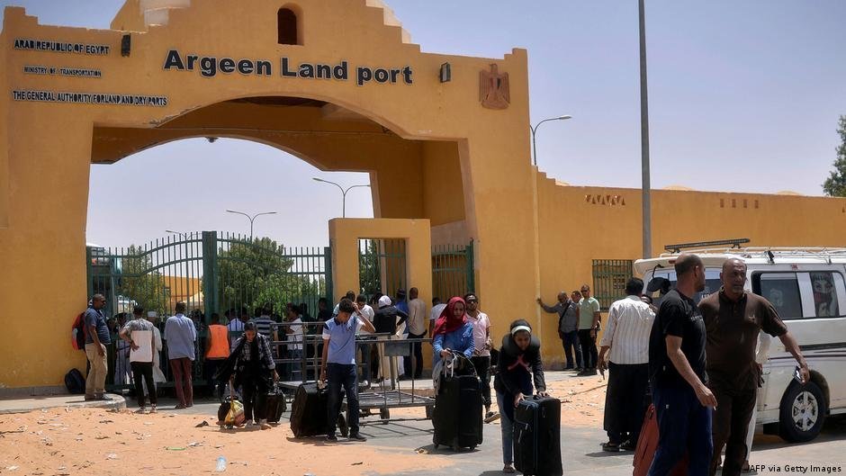 Après plusieurs jours d'attente devant le poste frontière, des Soudanais passent en Égypte où ils reçoivent de l'eau et de la nourriture. Crédit : AFP/Getty